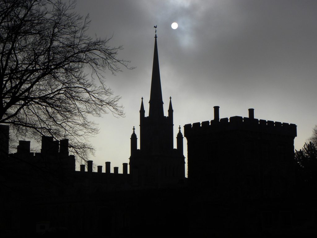 A picture of Ashridge college silhouetted against a moonlit sky